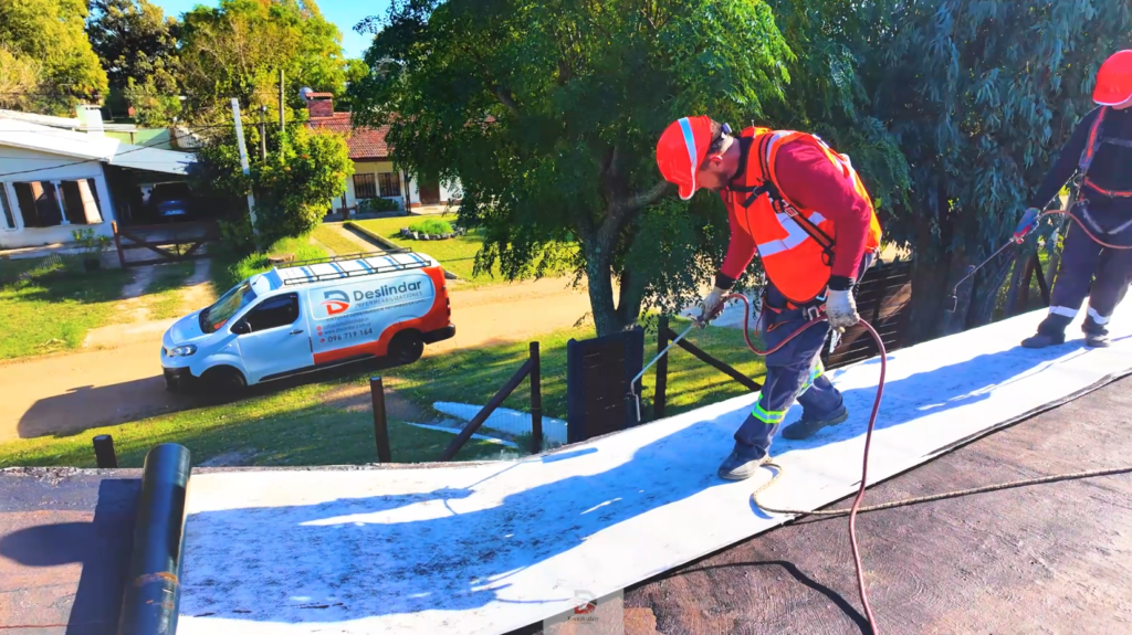 Operarios de Deslindar realizando impermeabilización de techos con membrana en una propiedad en Uruguay.